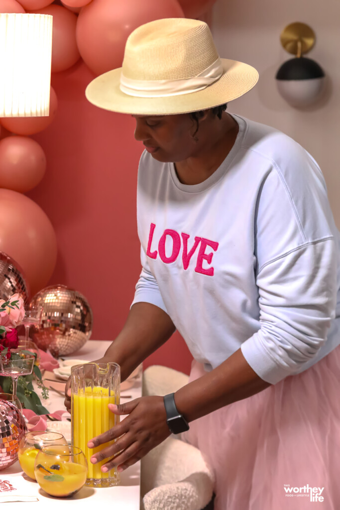 woman holding a pitcher of orange juice