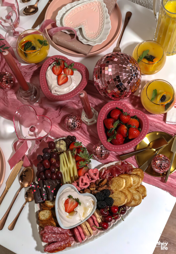 a heart-shaped platter filled with food for a charcuterie board