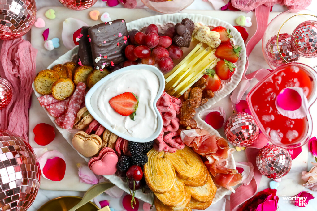 a heart-shaped platter filled with food for a charcuterie board