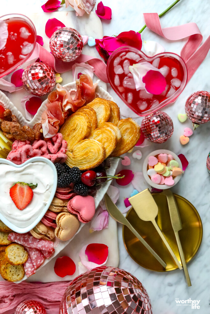 a heart-shaped platter filled with food for a charcuterie board