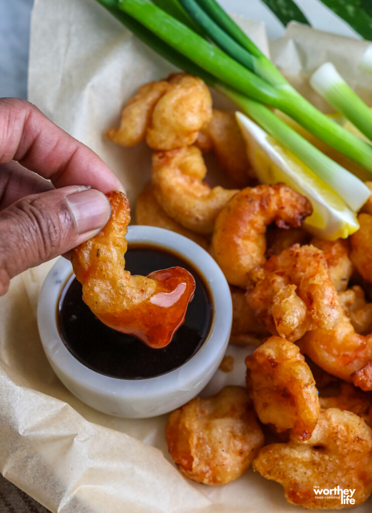 man dipping his shrimp into a guinness glaze