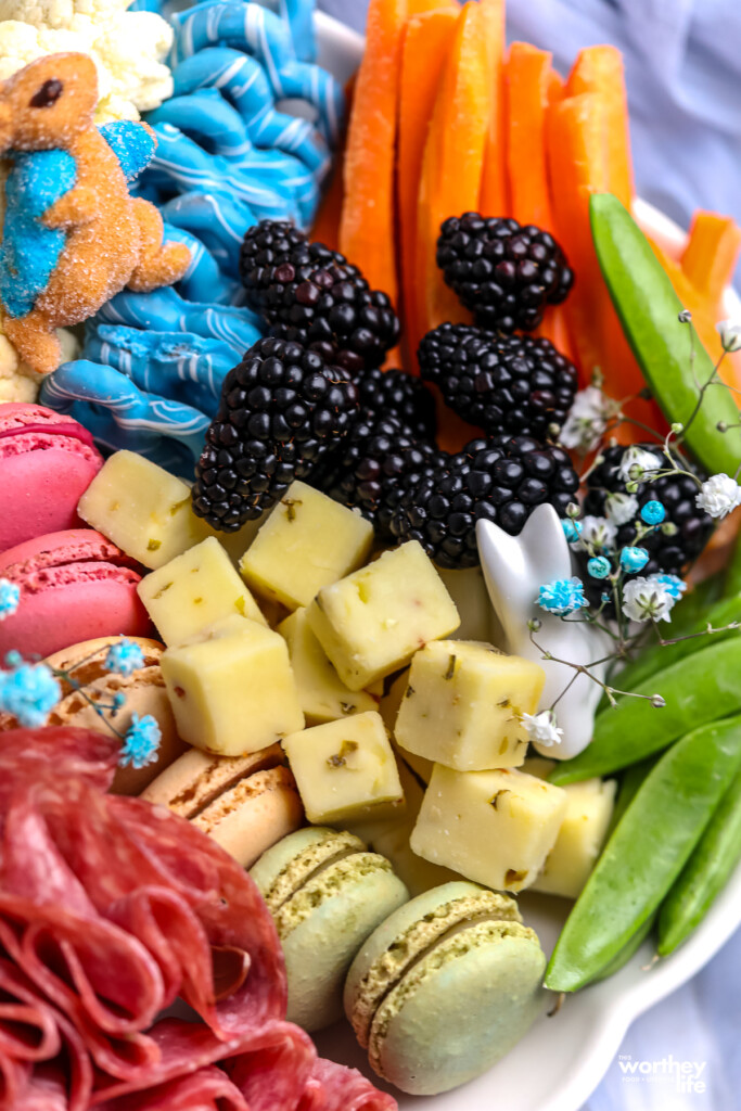 meat, cubed cheese and blackberries, carrots on a white platter