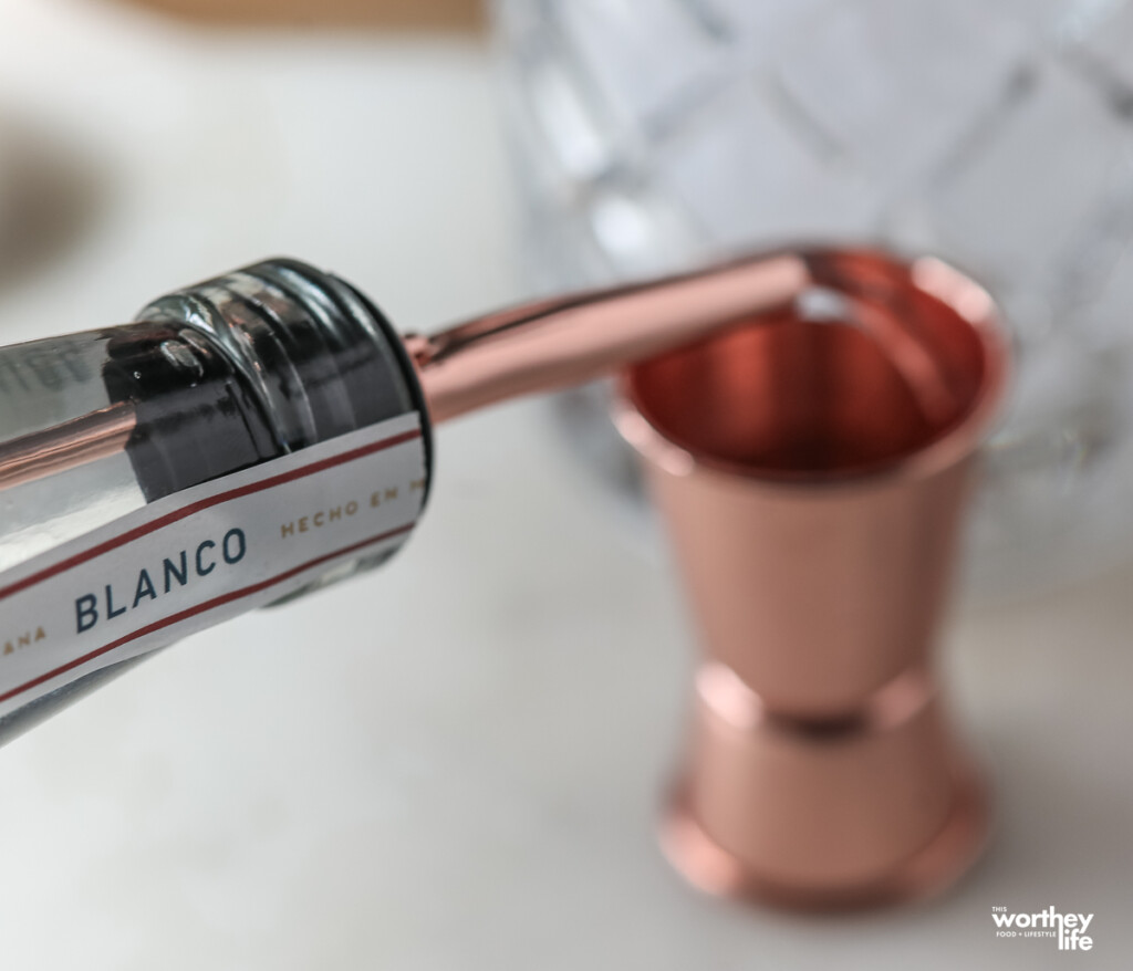 pouring tequila into a jigger