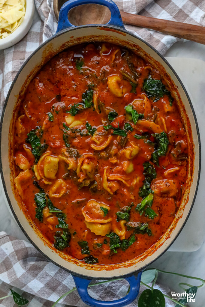 Creamy Tomato Tortellini Soup with Kale in a blue dutch oven