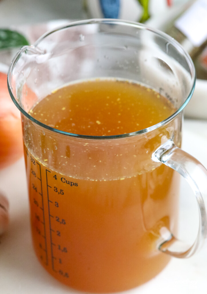 chicken stock in a measuring cup