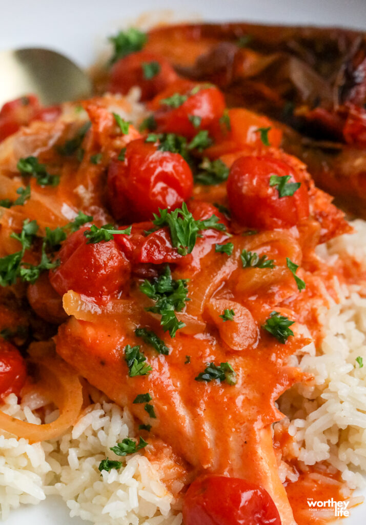 salmon filet with creamy tomato sauce on a bed of rice