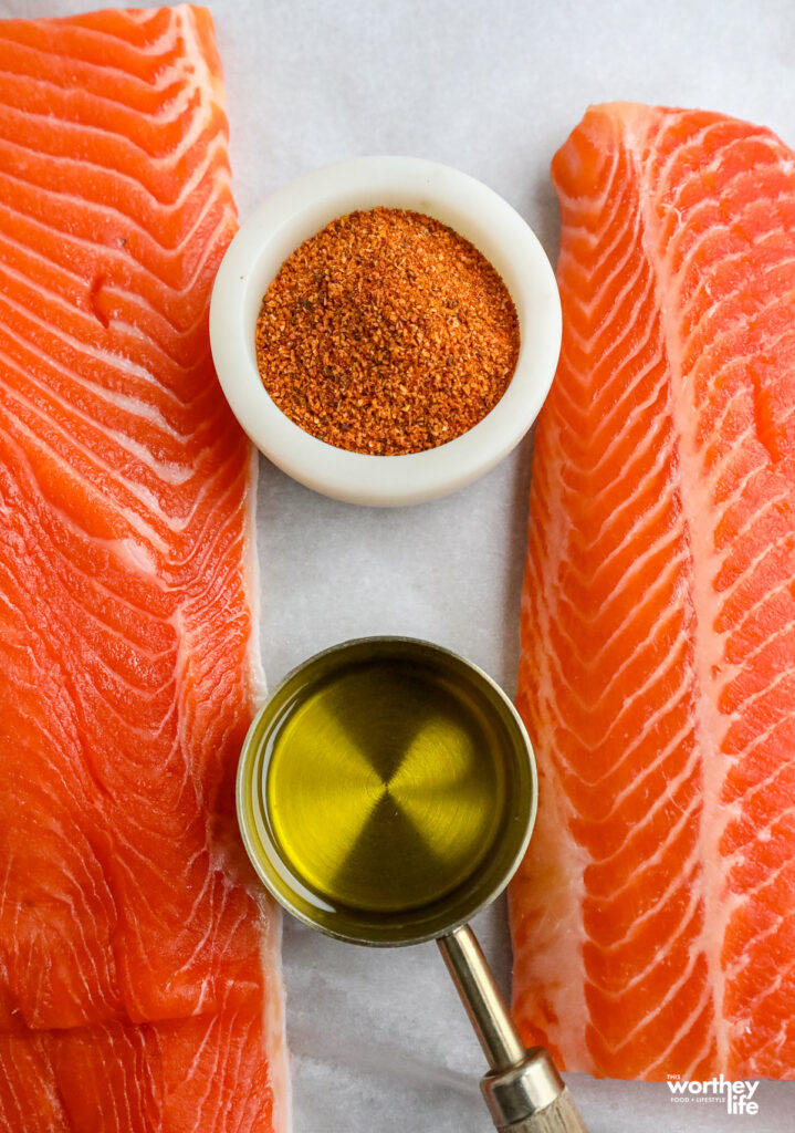 ingredients to prep for baking a salmon on a marble background