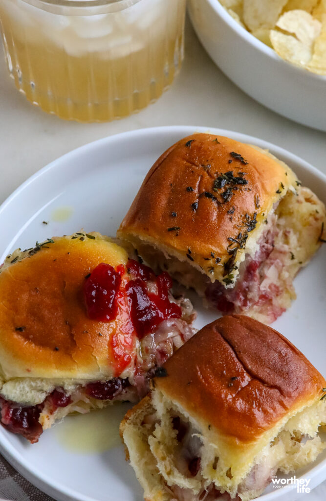 cranberry and turkey sliders on a white plate with cranberry on top